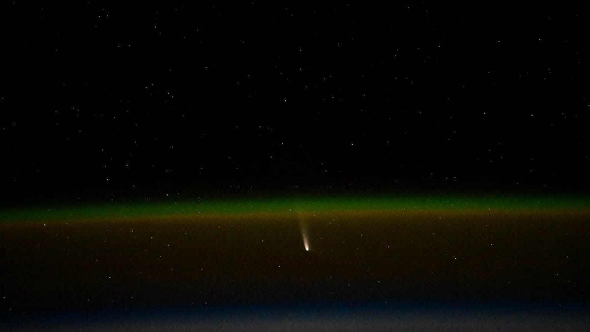 Green curve of Earth&apos;s atmosphere with bright splash of Comet A3 in the center.